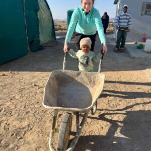 small child pushing a wheelbarrow