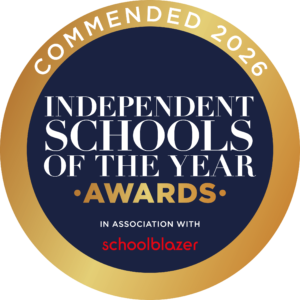 Circular navy badge with a gold gradient outer ring displaying 'INDEPENDENT SCHOOLS OF THE YEAR' and 'AWARDS', plus a red 'schoolblazer' wordmark at the bottom.